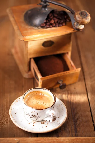 Una taza de café expreso con mesa texturizada molino de café antiguo — Foto de Stock