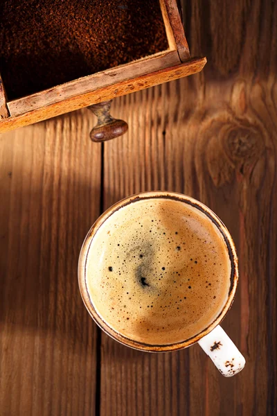 A cup of espresso coffee with Old coffee mill textured table — Stock Photo, Image