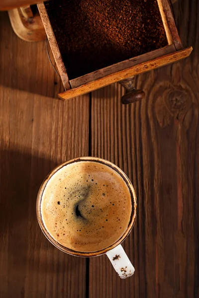 A cup of espresso coffee with Old coffee mill textured table — Stock Photo, Image