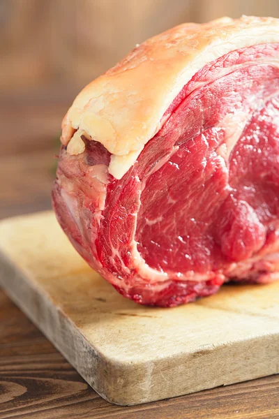 Ruwe rundvlees rib biefstuk met been op houten plank en tabel — Stockfoto