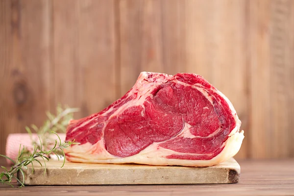 Raw beef Rib steak with bone on wooden board and table — Stock Photo, Image