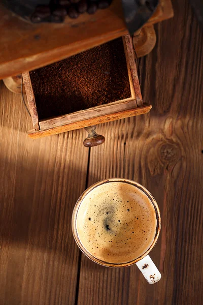 A cup of espresso coffee with Old coffee mill textured table — Stock Photo, Image