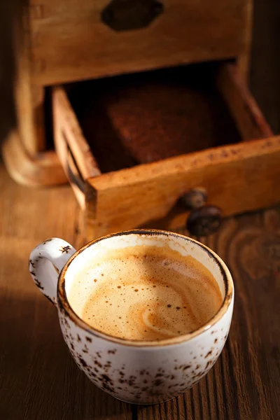 Una tazza di caffè espresso con Old coffee mill tavolo strutturato — Foto Stock