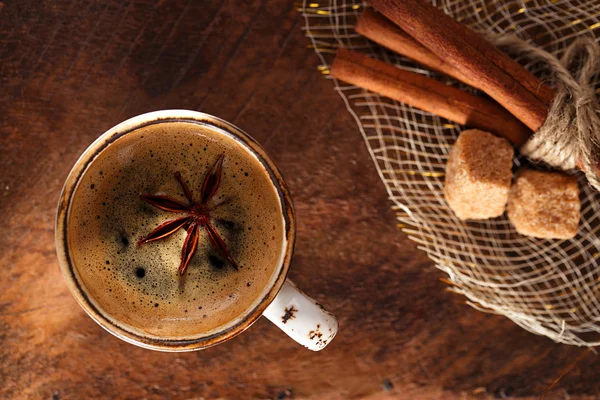 Une tasse de café épicé avec anis star et bâtonnets de cinamon et de sucre — Photo
