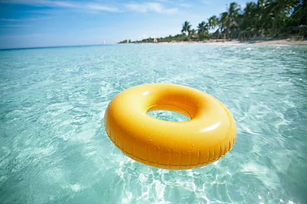 Плавающее кольцо на голубом чистом море с пляжем, мелководье dof — стоковое фото
