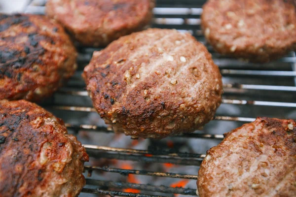 Eten vlees - rundvlees hamburgers op BBQ-barbecue grill met vlam — Stockfoto