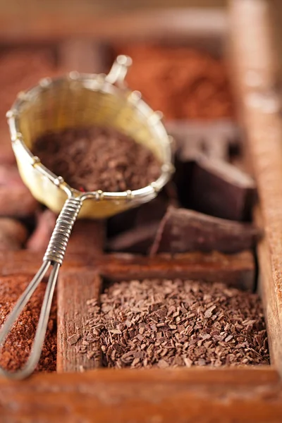 Hot chocolate flakes  in old rustic style silver sieve on wooden — Stock Photo, Image