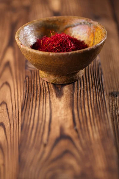 Saffron spice in earthenware bowl — Stock Photo, Image