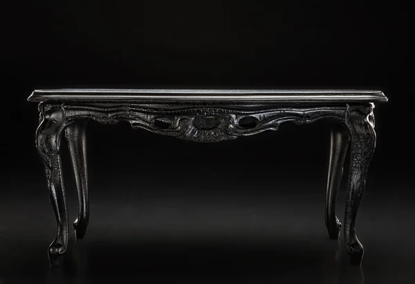 Schwarz, ein alter Tisch mit geschnitzter Struktur — Stockfoto
