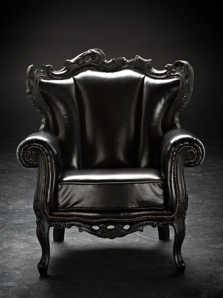 Old black chair, upholstered in leather, isolated on a black bac — Stock Photo, Image