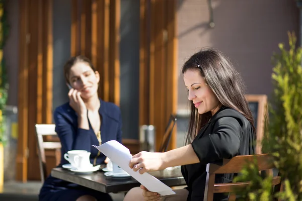 Dwie kobiety biznesu, siedząc przy stoliku w kawiarni na ulicy — Zdjęcie stockowe