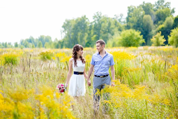 Portrait of a boy and a girl walking in a field of tall yellow g — Stock Photo, Image
