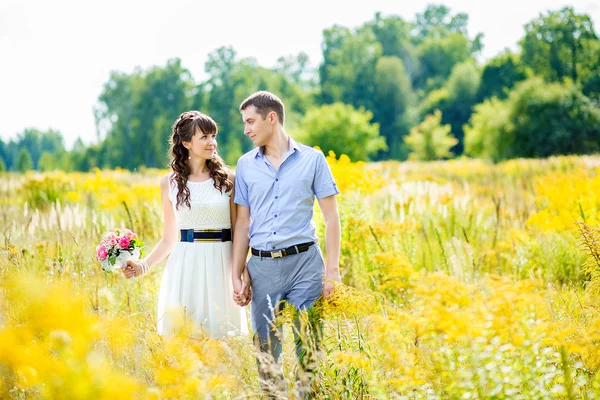 Retrato de um menino e uma menina andando em um campo de alta g amarelo — Fotografia de Stock