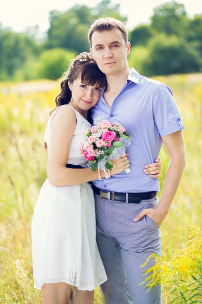 Portrait of a boy and a girl with a bouquet of standing against — Stock Photo, Image