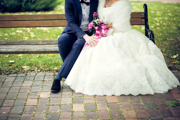 Bride and groom in bright clothes on the bench — Stock Photo, Image