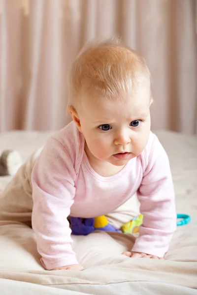Portrait of curious baby girl crawling on bed, closeup shot — Stock Photo, Image