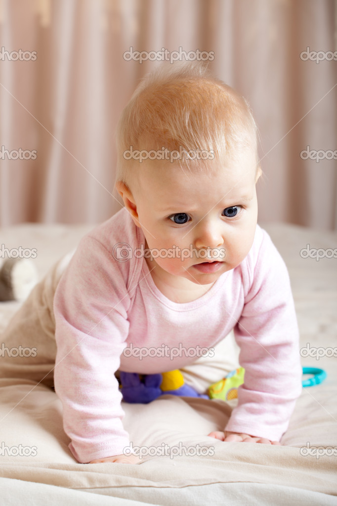 Portrait of curious baby girl crawling on bed, closeup shot