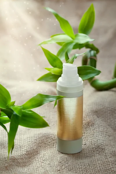 Face or body care concept - bottle of cream or shampoo with bamboo — Stock Photo, Image