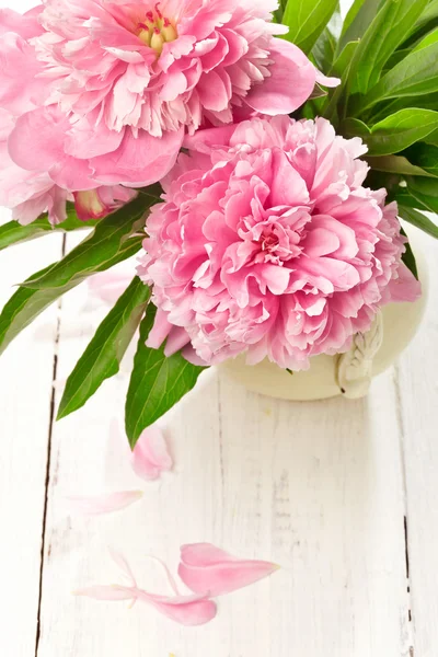 Pink peonies in retro vase on wooden table, closeup shot — Stock Photo, Image