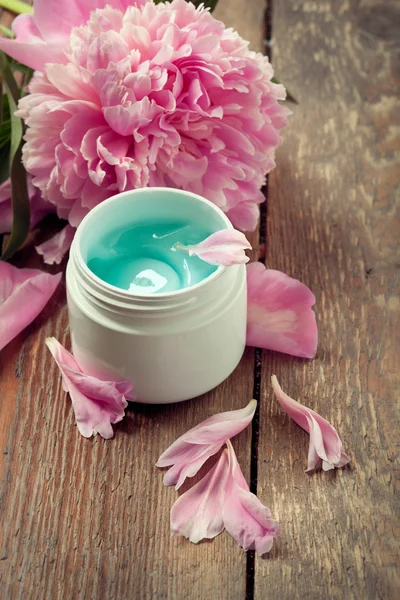 Face organic cream with peonies on an old wooden table — Stock Photo, Image
