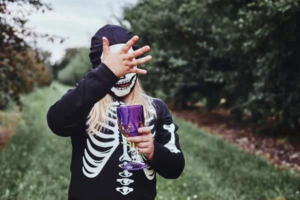 Cooles Teenie-Mädchen verkleidet als Skelett hat Spaß bei Halloween-Party und Tricks oder Behandlungen im Freien. — Stockfoto