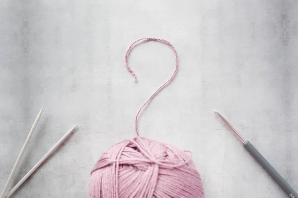 Tricoter ou crocheter - telle est la question. Boule de fil, crochet et aiguilles à tricoter rayons — Photo