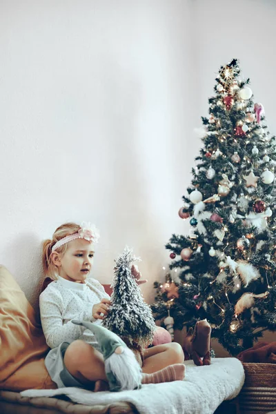 小女孩在圣诞树旁玩耍玩具和装饰品 — 图库照片
