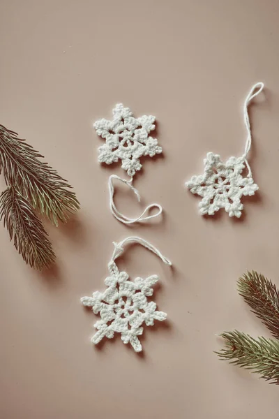 Nachhaltige und umweltfreundliche Weihnachtsdeko, handgehäkelte Baumwollschneeflocken, Flatlay auf beige — Stockfoto