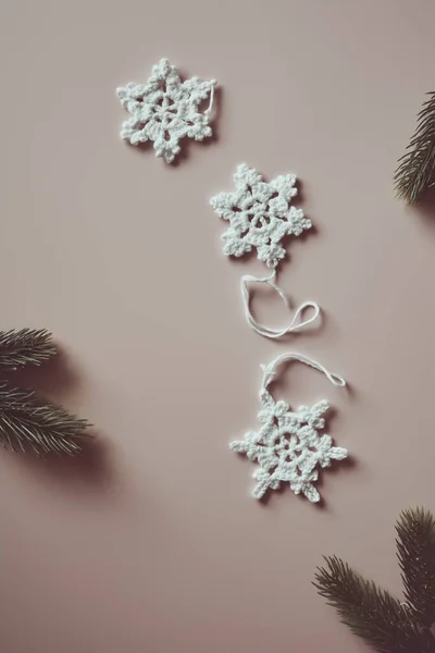 Deco de Navidad sostenible y respetuoso del medio ambiente, copos de nieve de algodón hechos a mano del ganchillo, flatlay en beige Imágenes de stock libres de derechos