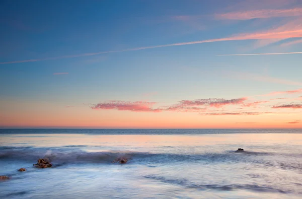 Beautiful sunset over Summer ocean with rocks and vibrant colors — Stock Photo, Image