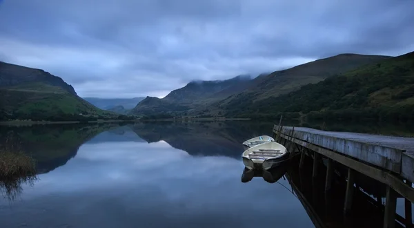 Llyn nantlle na východ slunce při pohledu směrem k mlhou zahalené hory sněhu — Stock fotografie