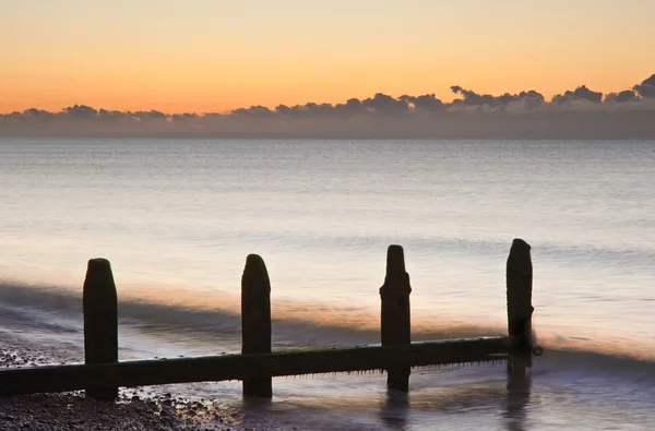 Παλιά groynes στην παραλία τελευταία άμυνα σε Ανατολή του ηλίου κατά παλίρροια — Φωτογραφία Αρχείου