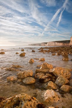 Yaz okyanus uçurumları, kayalar ve vibran güzel gün batımı