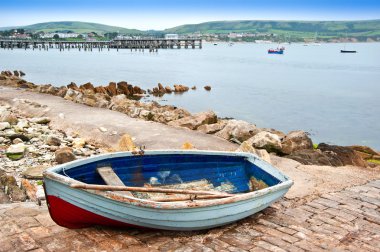 Old rowing boat on launch slipway of seaside town clipart