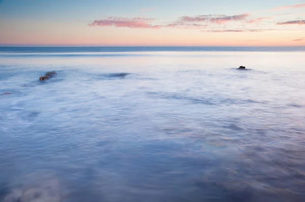 Belo pôr do sol sobre o oceano de verão com rochas e cores vibrantes — Fotografia de Stock