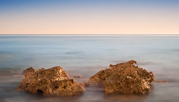 Vacker solnedgång över sommaren havet med stenar och levande färger — Stockfoto
