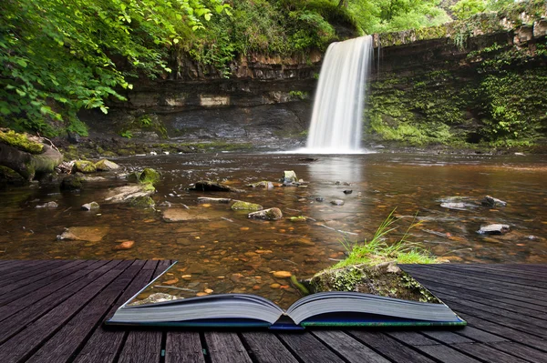 Creatief concept afbeelding van waterval in bos in pagina's van boek — Stockfoto