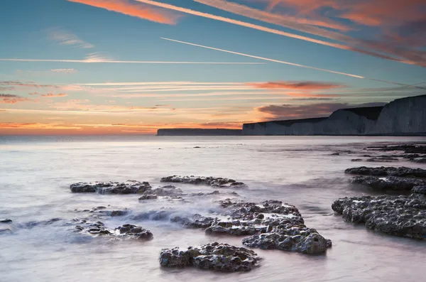 Bellissimo tramonto sull'oceano estivo con scogliere, rocce e vibrante — Foto Stock