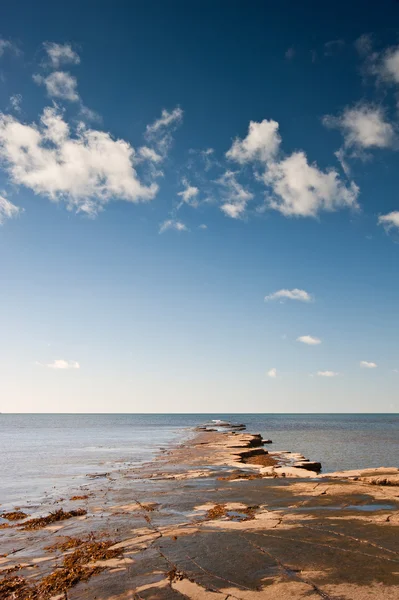 Seascape Kimmeridge zatoka z gzymsy rock odstają do morza na — Zdjęcie stockowe