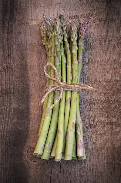 Fresh asparagus stalks on vintage wooden board — Stock Photo, Image