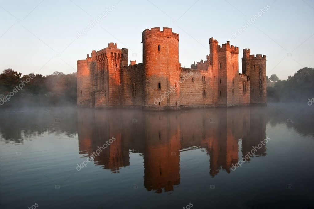 Stunning moat and castle in Autumn Fall sunrise with mist over m Stock