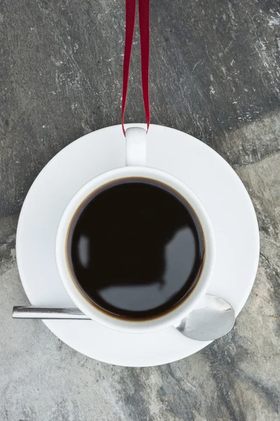 Coffee cup and saucer seeming ti hang impossibly without spillin — Stock Photo, Image