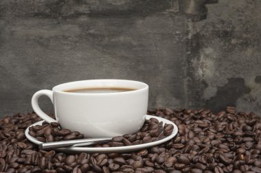dumanı tüten kahve koyu kahve çekirdekleri ile çevrili fincan sıcak