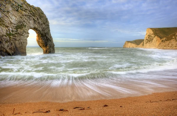 Vibrante alba sull'oceano con pila di rocce in primo piano — Foto Stock