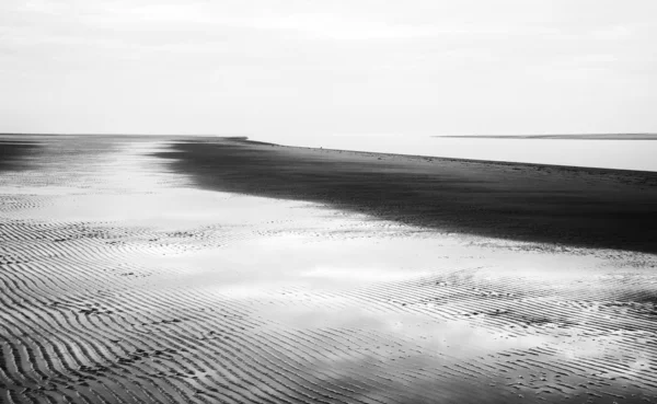 Black and white image of beach at low tide landscape — Stock Photo, Image