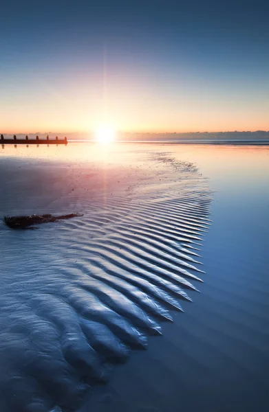 Hermosa playa de marea baja vibrante amanecer — Foto de Stock