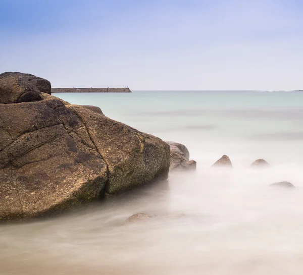 Pitkä altistuminen auringonlasku maisema kiviä rannalla — kuvapankkivalokuva