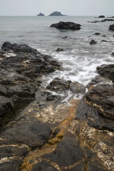 Felsiges Ufer und Brisons Rock in der Ferne am Kap Kornwall — Stockfoto
