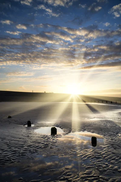 Vibrant sunrise landscape reflected in low tide water on beach — Stock Photo, Image