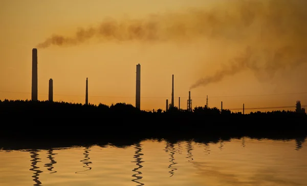 Industrial chimney stacks in natural landscape polluting the air — Stock Photo, Image